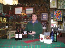 Sue Goold Miller offers samples of the new wines available at the Brookview Station Winery. They�re made from fruit grown at Goold Orchards. Photo by Kristen Shaw.